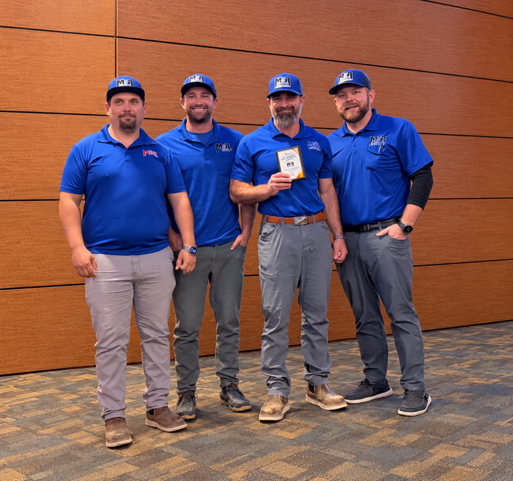 The owners of M&R Service in their blue company polos, smiling together